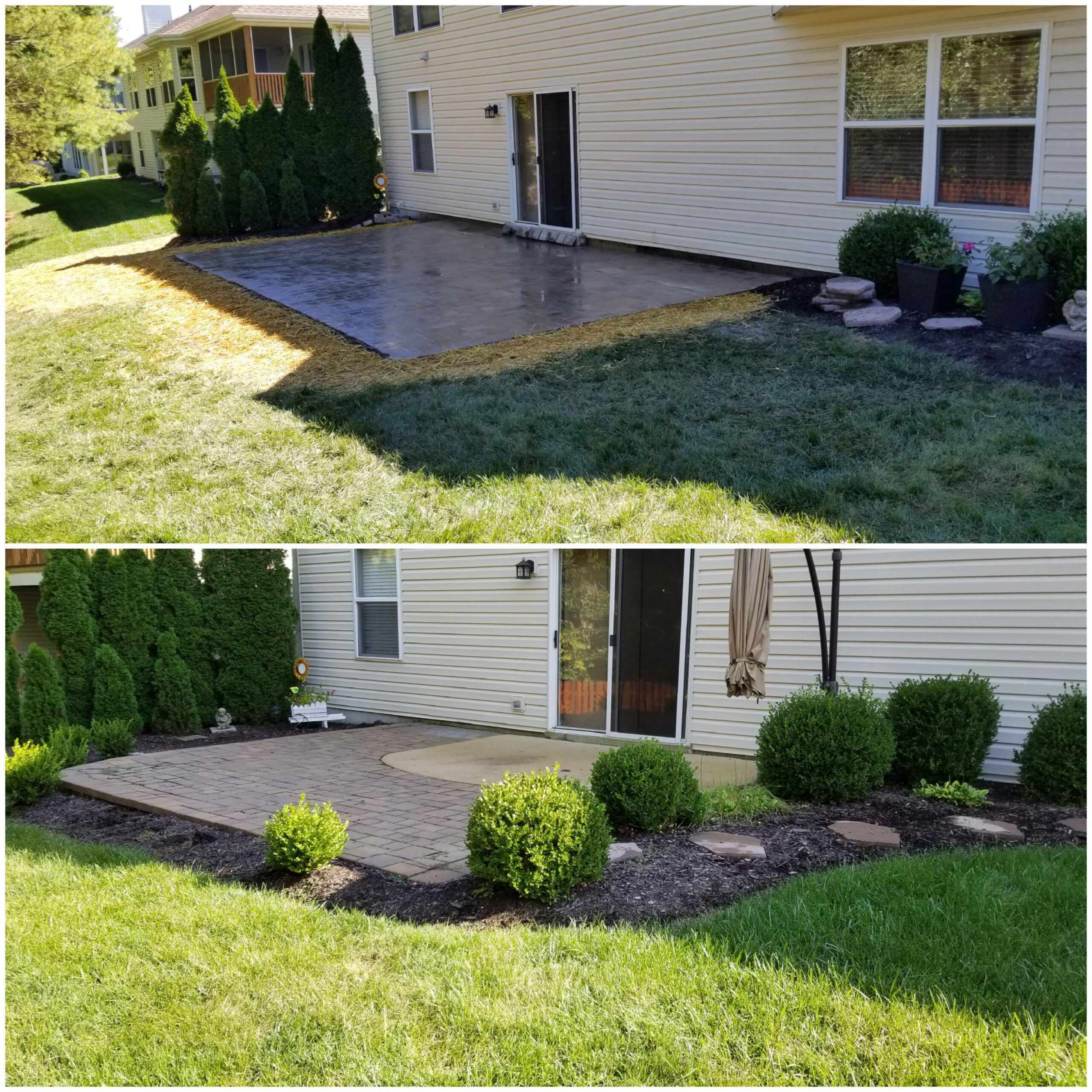 White house by a stream with a view of a forested hill.